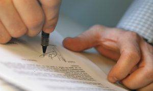 Man's Hands Signing Document